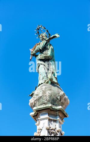 Vergine Maria statua su un obelisco di nuovo Gesù Plaza a Napoli, Italia Foto Stock