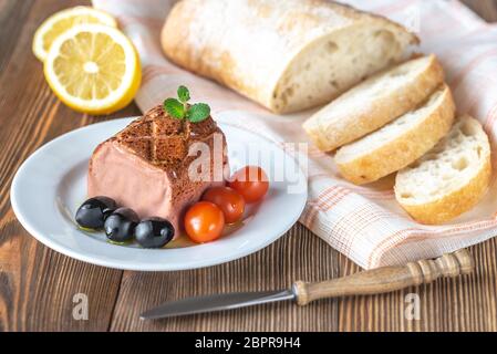 Di fegato di pollo con patè di olive nere, pomodorini e ciabatta sulla piastra bianca Foto Stock