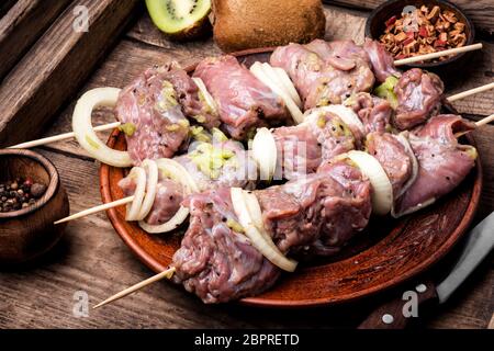 Crudo fresco spiedini di carne spiedini sulla piastra.Le carni preparate per la marinatura sul bordo di taglio Foto Stock