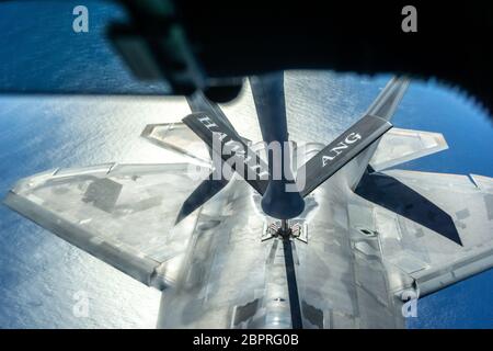 Un KC-135 Stratotanker gestito dal Team Hickam rifornisce un F-22 Raptor durante una missione di allenamento di routine sulle isole hawaiane, 14 maggio 2020. Durante la missione di addestramento gli equipaggi della Guardia Nazionale aerea delle Hawaii e la 15esima Ala aerea hanno condotto un volo in tutte le isole Hawaiiane come saluto a tutti i lavoratori di prima linea che lottano contro COVID-19, così come a coloro che rimangono a casa per 'flatten la curva di trasmissione' del virus. (STATI UNITI Air National Guard foto di Tech. SGT. Alison Bruce-Maldonado) Foto Stock