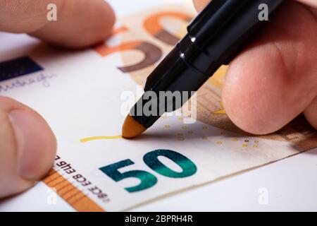 Close-up di scrittura a mano sulla banconota con marcatore giallo Foto Stock