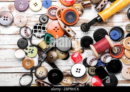 Rocchetti di fili e i pulsanti su un tavolo di legno. Strumento di cucitura Foto Stock