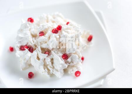 Porzione di meringa con i semi di melograno Foto Stock