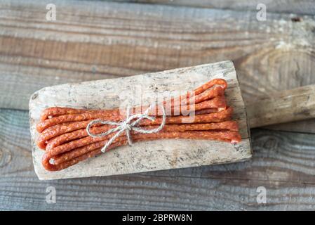 Salsicce affumicate sullo sfondo di legno Foto Stock