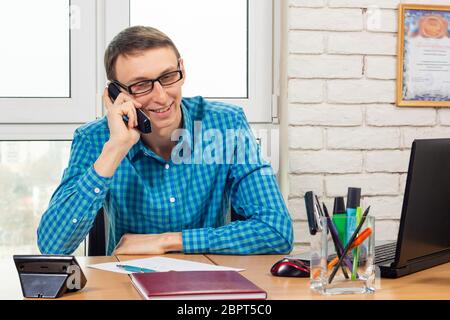 Specialista di Office con un sorriso a parlare al telefono Foto Stock