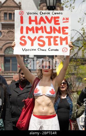 Una donna protesta i vaccini obbligatori in un raduno per porre fine alla chiusura della COVID-19 fuori dall'Assemblea legislativa dell'Ontario al Queen's Park di Toronto. Foto Stock