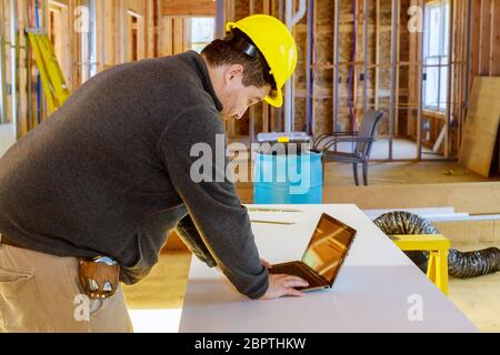 Ispettore in nuova casa di costruzione con tablet che fa appunti esamina i documenti. Foto Stock