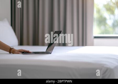 Immagine di una donna in primo piano utilizzando e digitando sul computer portatile sul letto Foto Stock