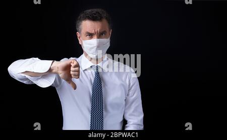 Un uomo che indossa la maschera medica e lavora da casa Foto Stock