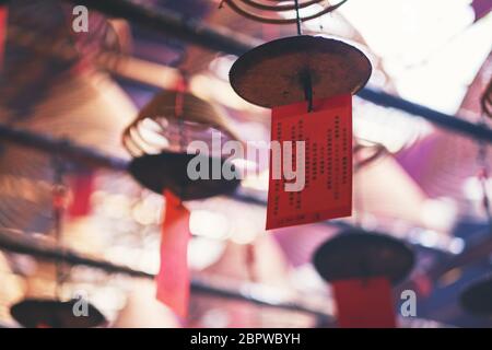 Immagine closeup di incensi a spirale appesi al soffitto nel tempio cinese Foto Stock