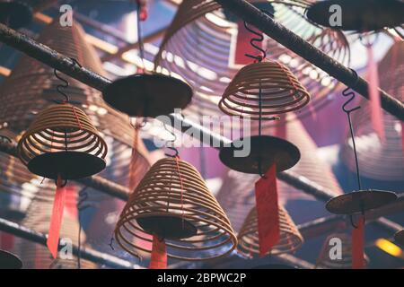 Immagine closeup di incensi a spirale appesi al soffitto nel tempio cinese Foto Stock