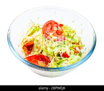 insalata di verdure di pomodori freschi tritati e cavolo tritato in una ciotola di vetro isolata su sfondo bianco Foto Stock