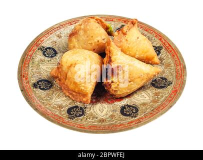 Cucina indiana - porzione di keema samosas (pasticceria salata fritta ripiena di carne e verdure) su piatto di ottone isolato su sfondo bianco Foto Stock