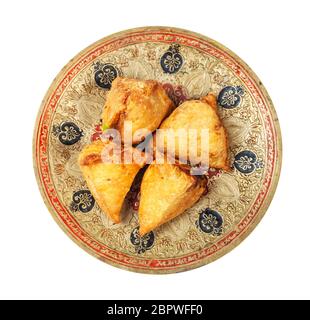 Cucina indiana - vista dall'alto di samosas vegetali (pasticceria salata fritta ripiena di purè di patate e verdure) su piatto di ottone isolato su backgrou bianco Foto Stock