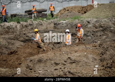 Bucarest, Romania - 14 maggio 2020: I lavoratori asiatici del settore edile in un cantiere a Bucarest. Foto Stock