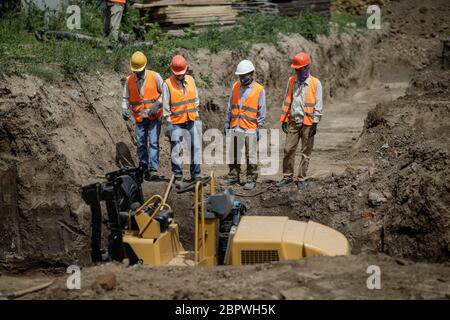 Bucarest, Romania - 14 maggio 2020: I lavoratori asiatici del settore edile in un cantiere a Bucarest. Foto Stock