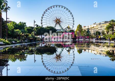 Vista panoramica della ruota panoramica di Nizza che si riflette nelle acque delle fontane della Promenade du Paillon. Nizza, Francia, gennaio 2020 Foto Stock