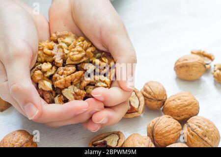 Noci biologiche nel cuore su sfondo di legno Foto Stock