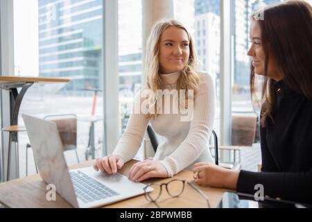 Studentesse che lavorano al progetto scolastico presso un moderno bar in città Foto Stock