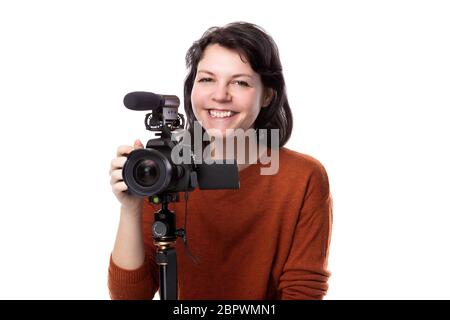 Studentessa d'arte che studia per essere un regista usando una macchina fotografica su un treppiede per un progetto. Sembra fiduciosa della sua creatività. Raffigura gli animatori Foto Stock