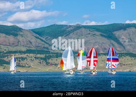 Regata di yacht con vela a colori in una mattina foggy galleggia sul mare. Ampio panorama. Foto Stock