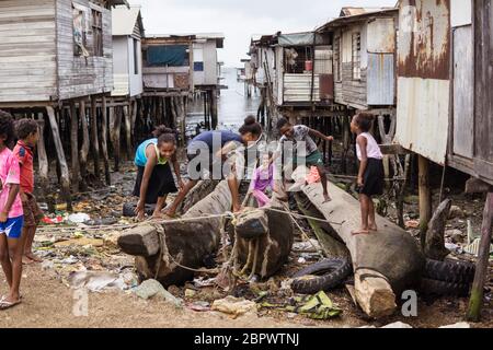 Port Moresby / Papua Nuova Guinea: Gruppo di bambini Papuan che giocano in un villaggio galleggiante in legno Foto Stock