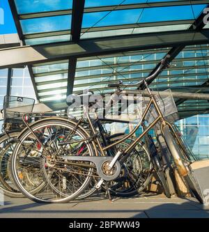 Primo piano delle biciclette in auto dall aeroporto internazionale di Kastrup sotto la tettoia di vetro nella giornata del sole, Copenhagen, Danimarca Foto Stock