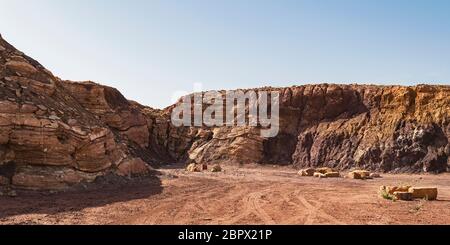 Strati di calcare dominano la sinistra e la metà di questa cava abbandonata nel cratere Ramon in Israele, mentre vari depositi di argilla sono sulla destra Foto Stock