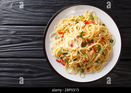 Spaghetti aglio e olio gli spaghetti all'aglio e all'olio sono un piatto di pasta tradizionale di Napoli da vicino in un piatto sul tavolo. Orizzontale Foto Stock