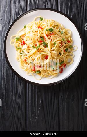 Napoli tradizionale aglio e olio spaghetti primo piano in un piatto sul tavolo. Vista dall'alto verticale Foto Stock