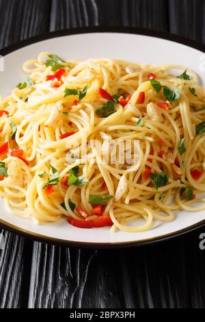 Napoli tradizionale aglio e olio spaghetti primo piano in un piatto sul tavolo. Verticale Foto Stock