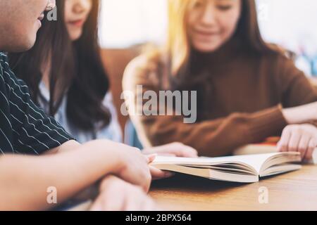 Un gruppo di giovani goduto la lettura dello stesso libro insieme Foto Stock