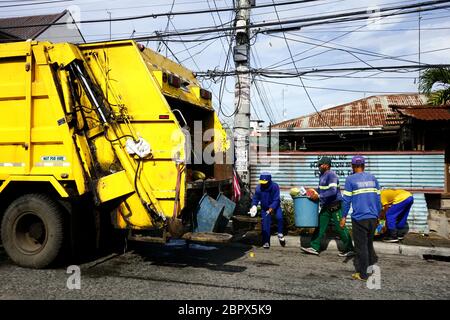 Antipolo City, Filippine - 16 maggio 2020: I raccoglitori di rifiuti mettono la spazzatura e la spazzatura ad un camion di spazzatura. Foto Stock