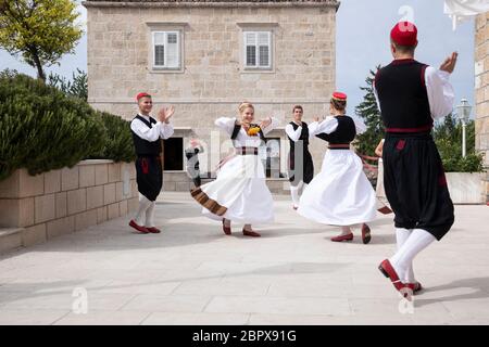 Konavle, Croazia, Oktober 5 2019. Uomini e donne che indossano costumi tradizionali del folclore croato mentre ballano ed eseguono uno spettacolo in una zona rurale w Foto Stock