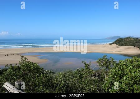 Vista su un fiume durante la bassa marea che scorre verso l'oceano Indiano Foto Stock