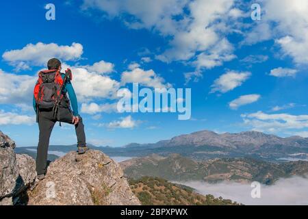 escursionista che ammira dalla cima le montagne del parco naturale di grazalema, andalusia Foto Stock