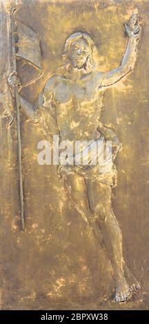 La figura di Gesù Cristo in bronzo in bassorilievo. Il Redentore contiene un flag nella sua mano. Ideale per i concetti e gli sfondi Foto Stock