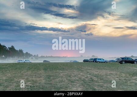 Parcheggio polveroso scenario dello spazio su un campo compreso un sacco di polvere auto coperti in serata nella Germania meridionale Foto Stock