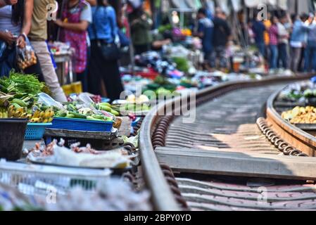 La vendita di cibo sul Maeklong mercato ferroviario in Thailandia. Foto Stock