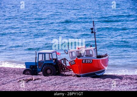 Un vecchio trattore con la Union Jack e Bransombe l'unica barca da pesca sulla spiaggia di Branscombe. Jurassic Coast, Devon, Gran Bretagna Foto Stock