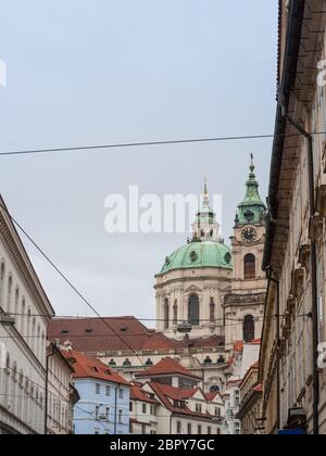 La Chiesa di San Nicola, chiamato anche Kostel Svateho Mikulase, a Praga Repubblica Ceca, con la sua cupola iconica visto da vicino le strade con il barocco tipico Foto Stock