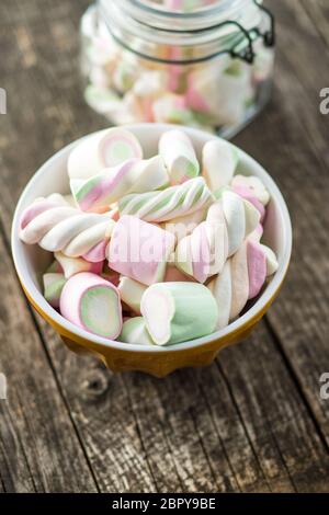 Dolci marshmallows colorati nella ciotola sul tavolo di legno. Foto Stock
