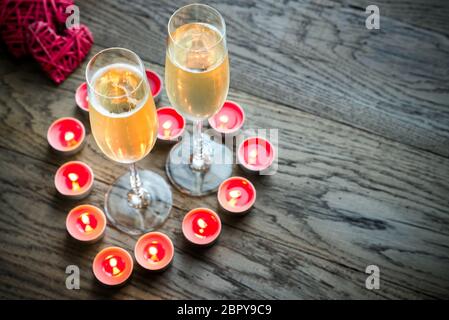 Due bicchieri di champagne all'interno di candele accese Foto Stock