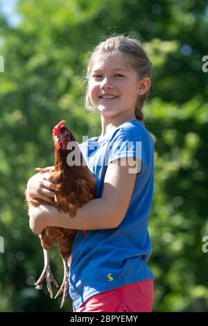 Lucy Broughton, di Retford, con le sue galline batteria salvate le cui uova sta vendendo per Bluebell Wood Children's Hospice a Rotherham. La nove anni, ha salvato le galline poco prima di chiudere la serratura in modo da potrebbe inizialmente dare le uova per libero a persone bloccate in auto-isolamento. Foto Stock