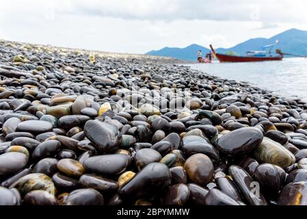 Barca dalla coda lunga portano i turisti viaggiare a Ko Hin Ngam isola e bella roccia con uno strano colore nero è un famoso attrazioni di Tarutao National Foto Stock