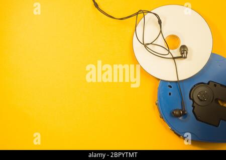 Lettore CD e CD con auricolari su sfondo giallo. Spazio per la copia Foto Stock