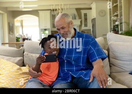 Uomo di razza misto senior con suo nipote che prende un selfie Foto Stock