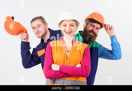 Team di architetti, costruttori, operai che si nascondono dietro il leader isolato sfondo bianco. Concetto leader femminile. Donna, leader in elmetto con felice piedi faccia di fronte a costruttori. Foto Stock