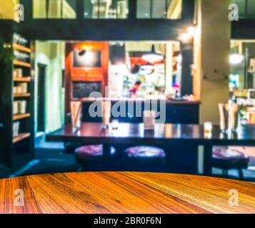 scenografia di tavolo in legno con sfondo offuscato astratto in ristorante aperto e bar.ready per montaggio di prodotti. . Foto Stock