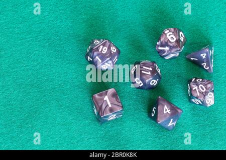 Grigio dadi poliedrica per Dungeons and Dragons gioco da tavolo a giocare sul green baize tabella con copyspace Foto Stock